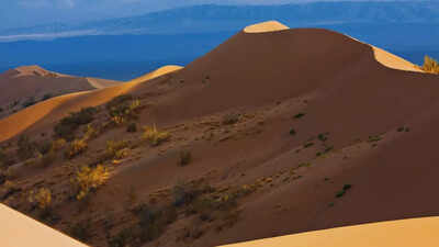 What is the mystery behind the Singing Dunes of Kazakhstan?