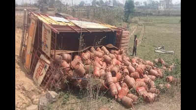 Truck carrying cylinders turns turtle