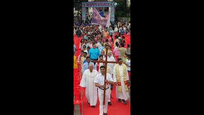 Marching across city, faithful sing paeans to Christ