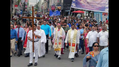 Marching across city, faithful sing paeans to Christ