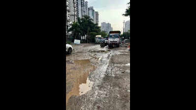 Road leading to school, condos littered with craters, flood-prone