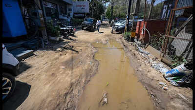 Illegal parking and broken service lane choke Old Mehrauli-Gurgaon Road