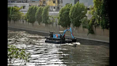 Floating hydraulic excavator to clean creeks