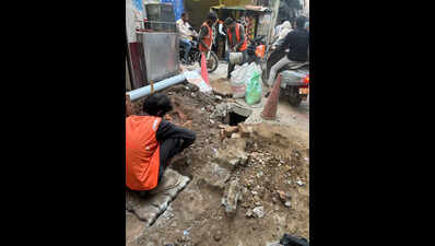 Sanitation workers clean drains without safety gear