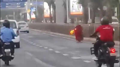 Red outfit, white cloth on head: Video shows woman running with burning object in hands on busy Ahmedabad road
