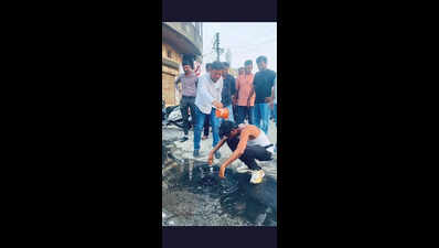 Corporator bathes in puddle to protest water wastage due to leaking pipeline