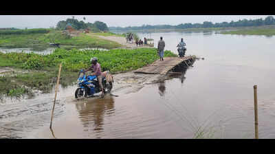 Bilasipara students wade through floodwaters as bamboo bridges submerge