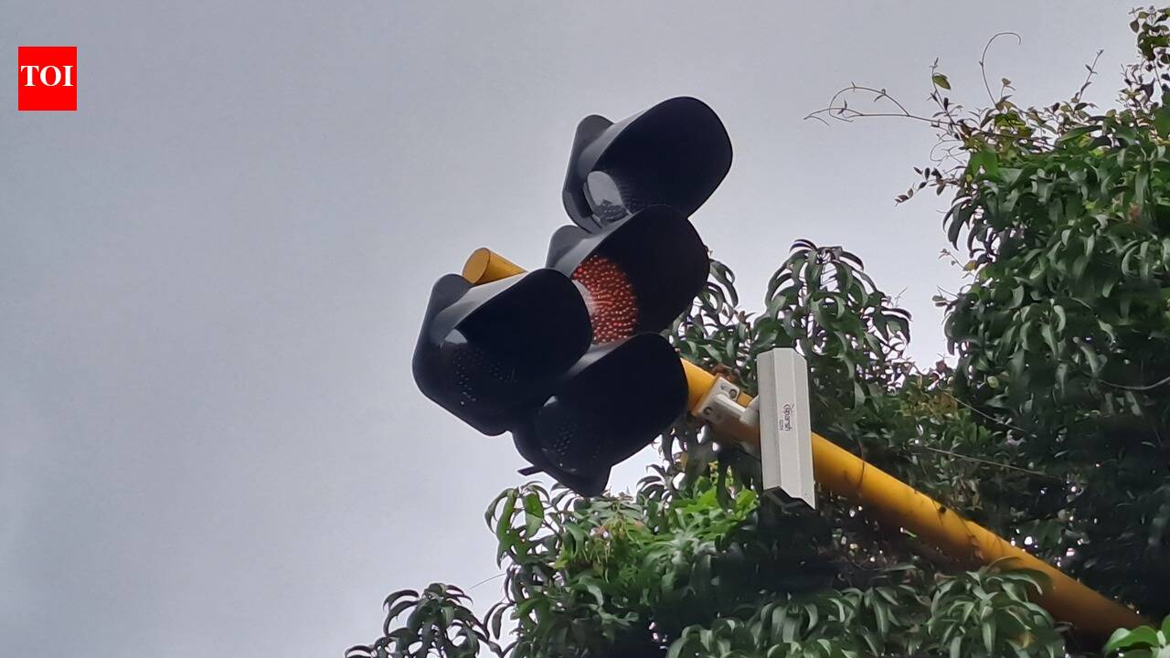 An AI traffic camera visibly sagging and pointing towards the ground against a blue sky in Colva, Goa.