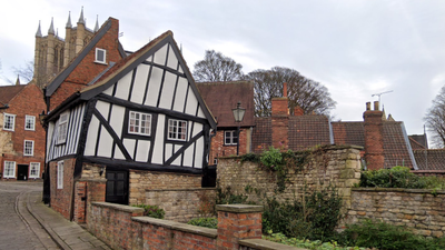 In 1933, Lincoln's Crooked House was marked for demolition; work revealed a hidden timber-framed building behind its brick façade and saved it; today it is one of the Cathedral Quarter's most photographed buildings