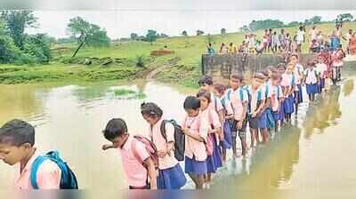 No bridge, Pakur children wade through overflowing check dam to reach school