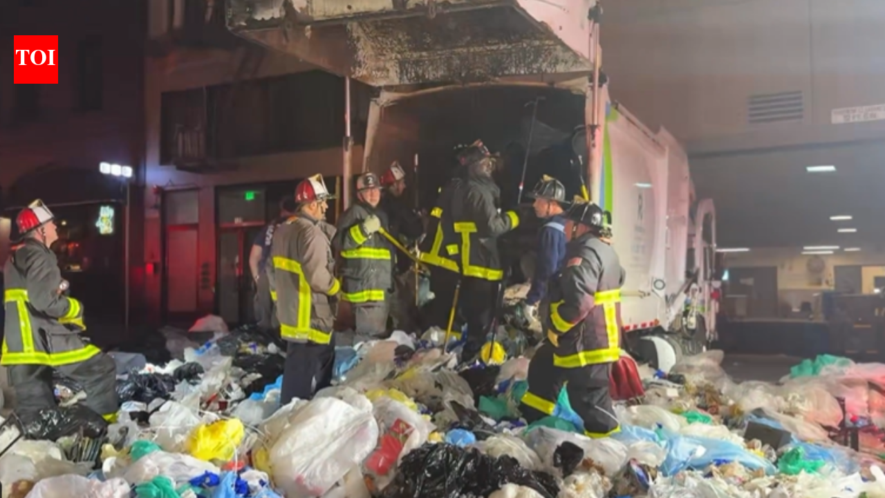 Bystander heard screams from a compacted garbage truck; 25 firefighters rescued a trapped man alive