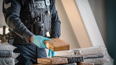 Vancouver workers opened a shipping container of T-shirts and found 14 duffle bags holding 329kg of cocaine worth C$5.8 million; police say it is the city's largest-ever cocaine seizure