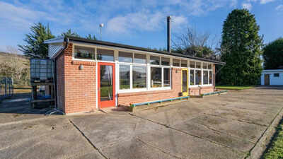 ​A New Zealand couple bought an abandoned school, then spent three years and about NZ$250,000 turning the classroom into a home and chalet; the property is now listed for enquiries over NZ$595,000