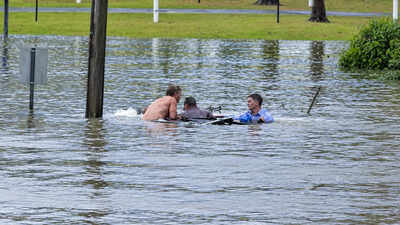 An Australian TV reporter was filming floods when he spotted a sinking four-wheel drive, swam out with a bystander and forced open a rear door to rescue the driver moments before the vehicle disappeared underwater