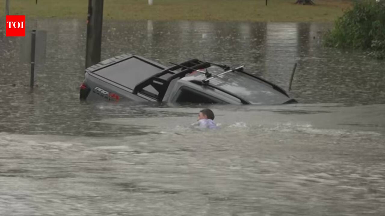 An Australian TV reporter was filming floods when he spotted a sinking four-wheel drive, swam out with a bystander and forced open a rear door to rescue the driver moments before the vehicle disappeared underwater