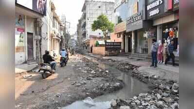 Road dug up for drain project, commuters wade on muddy stretch
