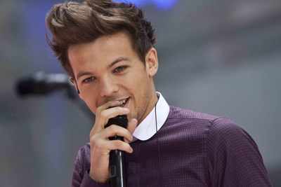 One Direction's Louis Tomlinson slips on stage