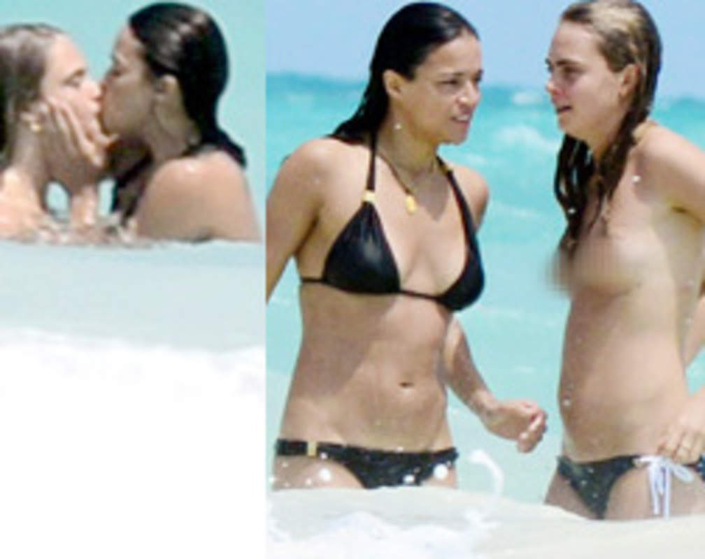 
Cara Delevingne kisses bikini-clad Michelle Rodriguez in sea
