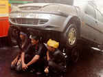 Cart pullers take shelter from rain under the car