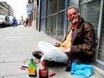 The beggar seems to care less about the alcohol bottles