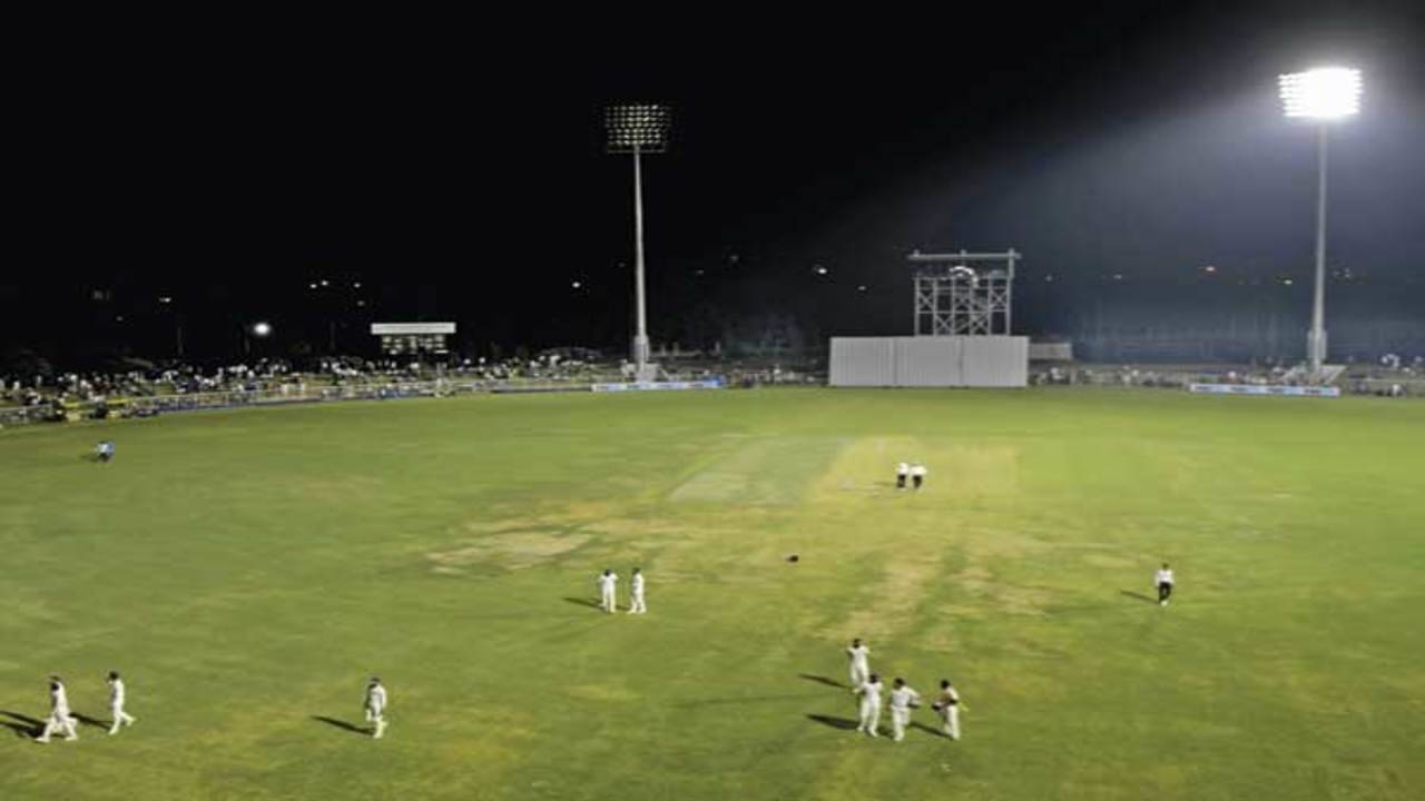 Crowd watching an evening baseball game played under floodlights