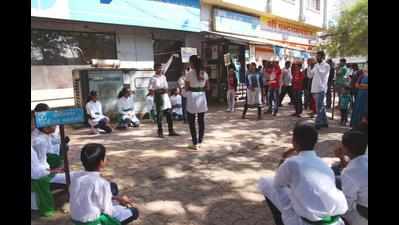 Students stage street plays for people standing in ATM queues