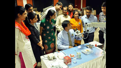 Dental college students learn to use microscope for surgeries