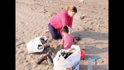Hungarian woman, her husband and children clean Vasai beach
