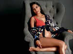 Pregnant Lisa Haydon sitting on a couch