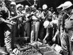 Police inspect an arms cache seized from a building