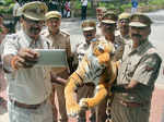 ​ Police personnel take a selfie with a toy tiger