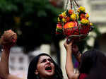 ​ A devotee breaks a clay pot containing curd
