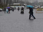 People wade through the waterlogged road