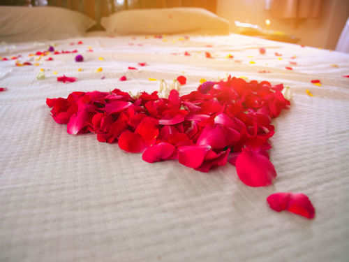 rose petals on bed with candles