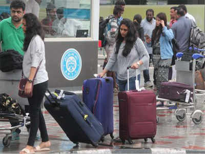 Passengers wait next to a giant suitcase outside the terminal building of  Bengaluru International Airport at its opening in Devanahalli, on the  outskirts of Bangalore, India, Friday, May 23, 2008. The Bengaluru