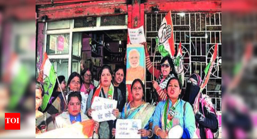 Congress women workers paste Modi's photos outside wine stores in