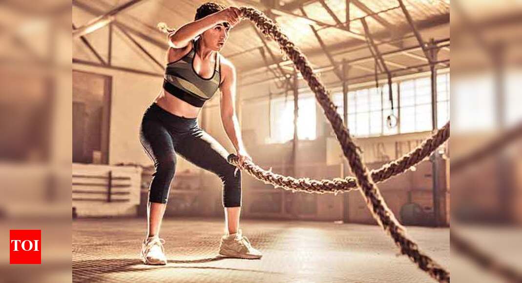 Gym 21. Man and woman holding Battle Ropes. Ropes of load.