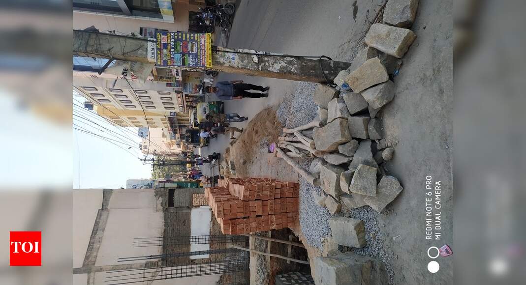 Footpath encroached by construction material - Times of India