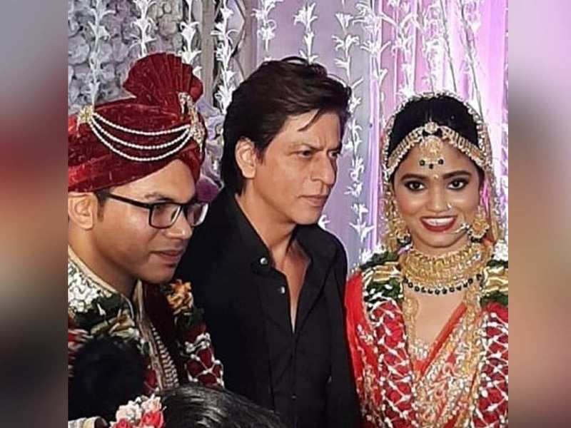 Shah Rukh Khan happily poses for pictures as he attends a wedding