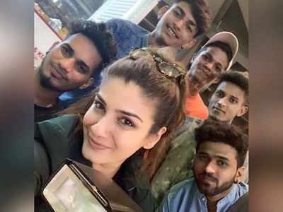 Raveena Tandon clicks a selfie with the paparazzi at the airport
