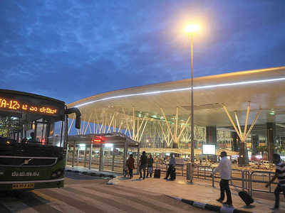 Passengers wait next to a giant suitcase outside the terminal building of  Bengaluru International Airport at its opening in Devanahalli, on the  outskirts of Bangalore, India, Friday, May 23, 2008. The Bengaluru