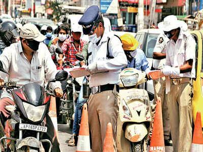 Traffic cops question commuters and register challans for violating lockdown norms in Vijayawada on Friday