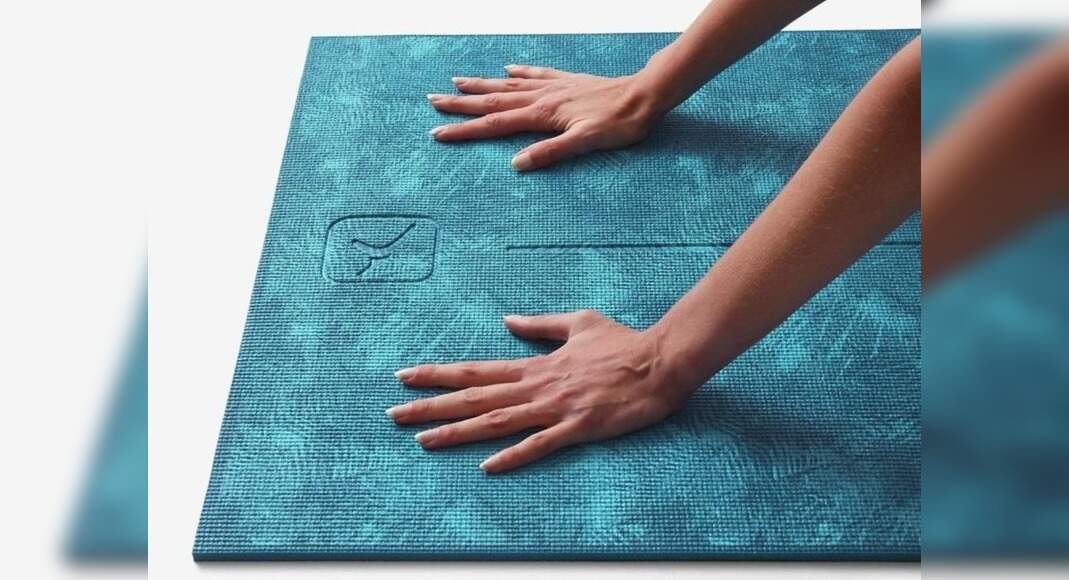 A girl cleaning a yoga mat with a cloth and spray bottle