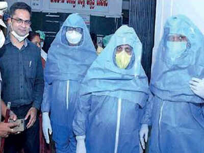 Home minister Basavaraj Bommai (centre) dons a PPE suit during his visit to a Covid-19 hospital in Haveri on Tuesday Karnataka Corona update: Under fire, Karnataka set out to relax quarantine rule for returnees | Bengaluru News