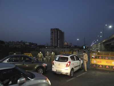 Police personnel check papers of vehicles and passes on the Delhi-UP border (AP Photo)