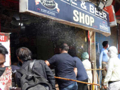 People outside a liquor shop in Delhi