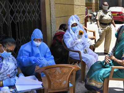 Medical doctors check the temperature of Dharavi resident
