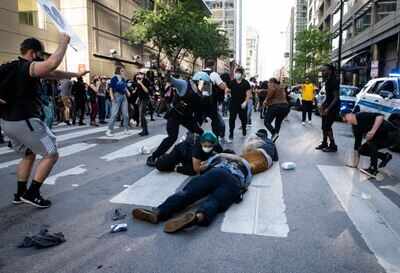 Chicago police officers clash with protesters near Kinzie and State as thousands of protesters joined national outrage over the death of George Floyd, who died in police custody in Minneapolis (AP)