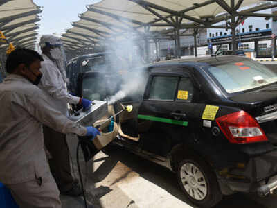 Taxi union staff members sanitize a taxi at Indira Gandhi International Airport in Delhi