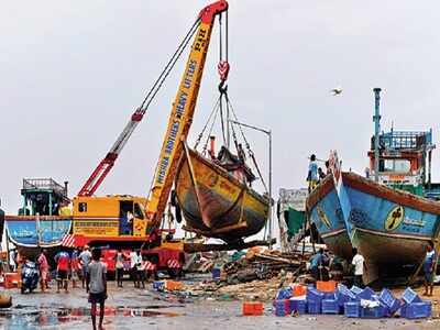 A crane lifts a boat to safety ahead of the cyclone at Madh village